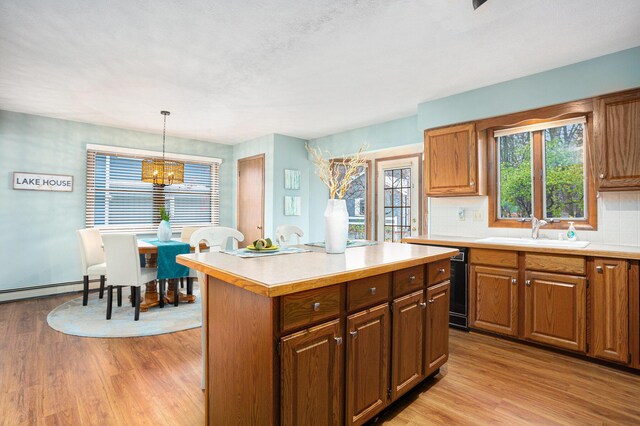 1875 Edwin Dr, Wayland, MI 49348 - kitchen featuring a sink, light countertops, light wood-style floors, and decorative backsplash