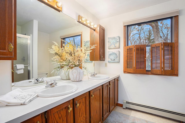 1875 Edwin Dr, Wayland, MI 49348 - bathroom featuring a baseboard radiator, double vanity, a stall shower, toilet, and baseboards