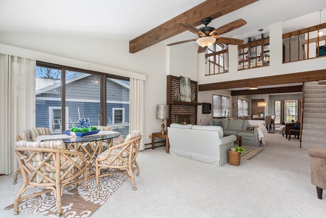 1875 Edwin Dr, Wayland, MI 49348 - carpeted living area featuring a fireplace, a ceiling fan, beam ceiling, baseboard heating, and high vaulted ceiling