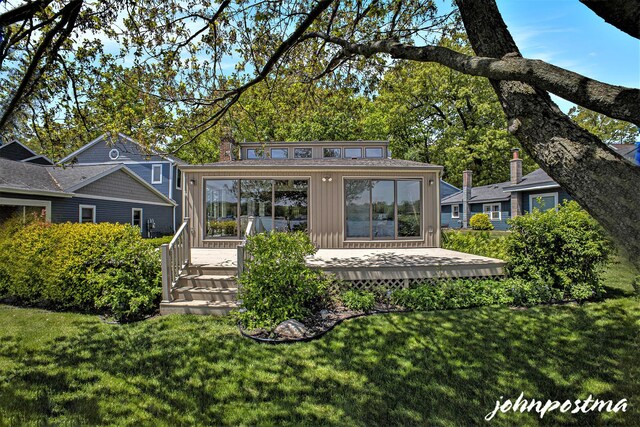 1875 Edwin Dr, Wayland, MI 49348 - back of property with a lawn, a wooden deck, an outbuilding, and board and batten siding