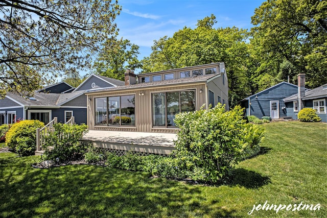 1875 Edwin Dr, Wayland, MI 49348 - rear view of property with a deck, board and batten siding, a yard, and a chimney