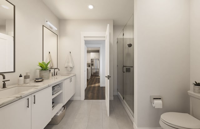 bathroom with tile patterned flooring, a shower with door, vanity, and toilet