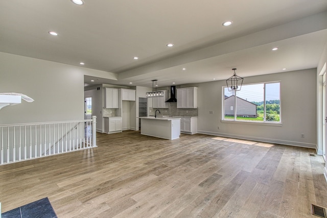 unfurnished living room with sink and light hardwood / wood-style floors