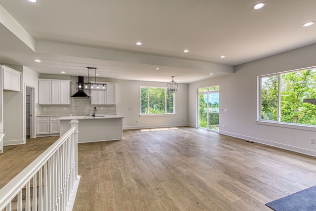 unfurnished living room featuring light hardwood / wood-style floors and sink