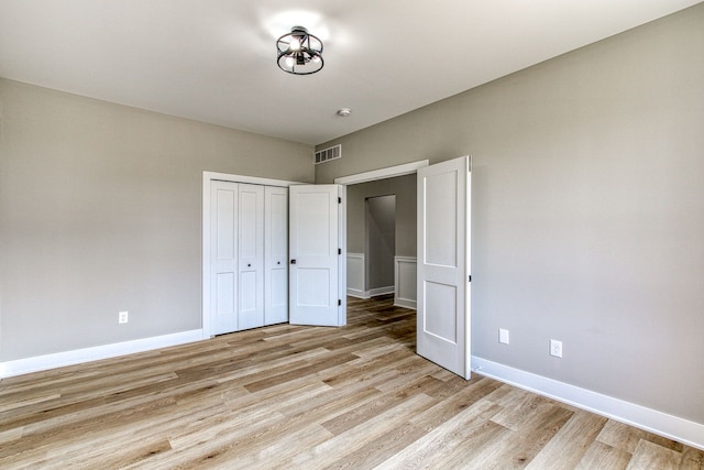 unfurnished bedroom with a closet and light hardwood / wood-style floors