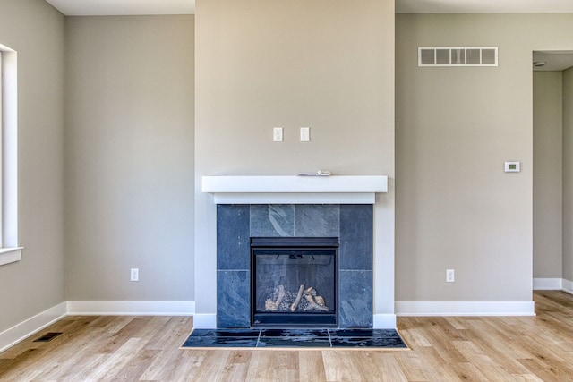 details featuring wood-type flooring and a tile fireplace