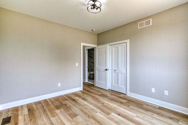 unfurnished bedroom with a closet and light hardwood / wood-style flooring