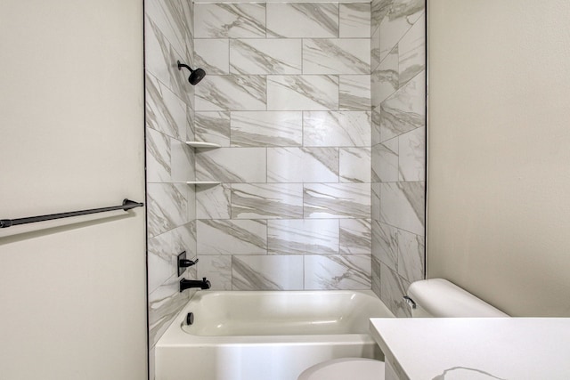 bathroom featuring toilet and tiled shower / bath