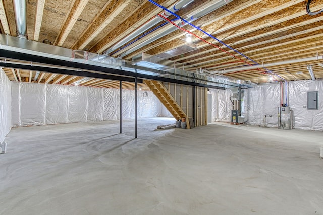 basement featuring electric panel and gas water heater