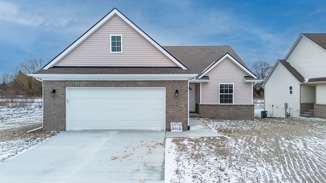 view of front of home featuring an attached garage, concrete driveway, brick siding, and a shingled roof