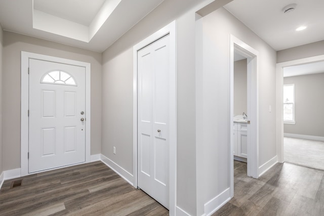 foyer featuring baseboards, dark wood-style flooring, and recessed lighting