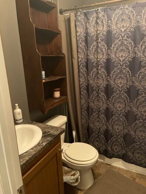 bathroom featuring tile patterned flooring, vanity, a shower with shower curtain, and toilet