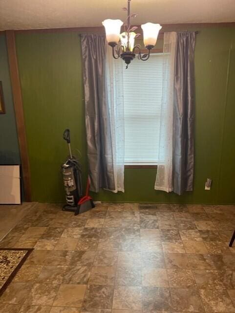 unfurnished dining area featuring a chandelier