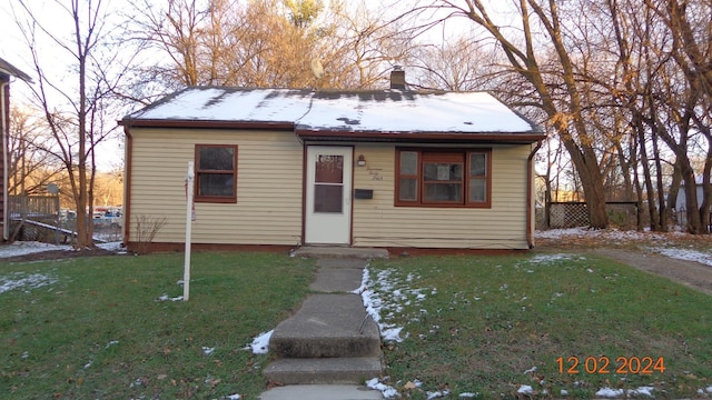 bungalow-style house featuring a front lawn