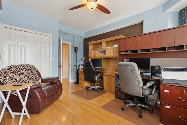 office featuring ceiling fan, light hardwood / wood-style floors, and a textured ceiling