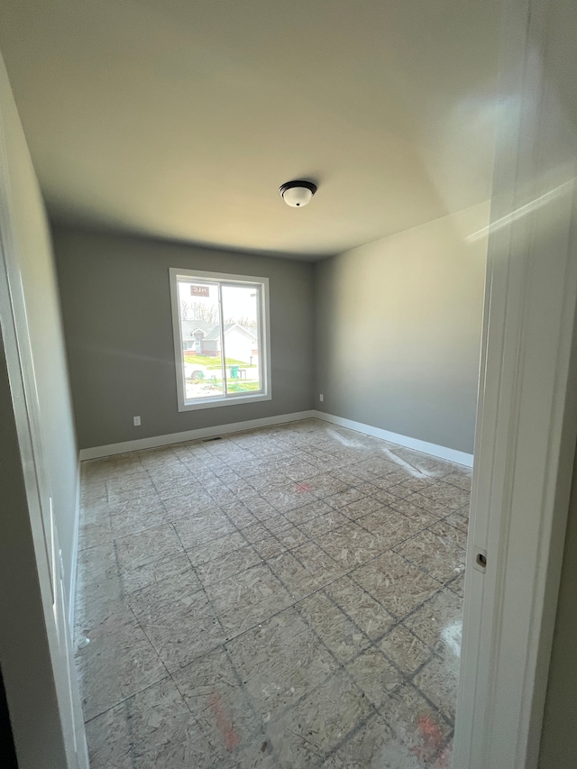 unfurnished room featuring baseboards