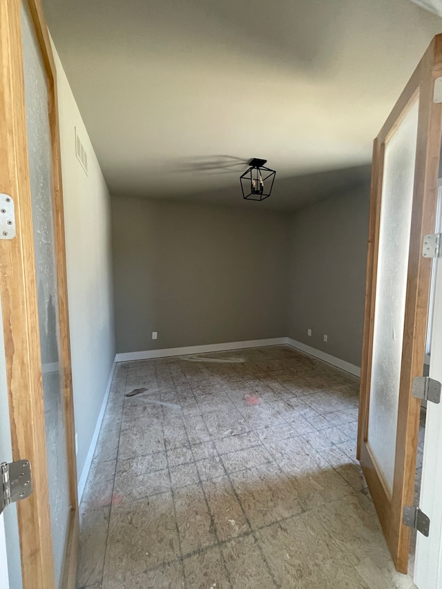 spare room featuring baseboards and visible vents