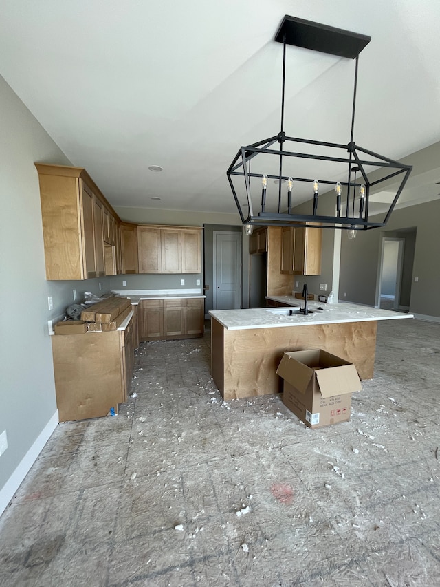 kitchen with a sink, baseboards, pendant lighting, and light countertops