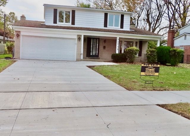 front facade featuring covered porch, a garage, and a front lawn