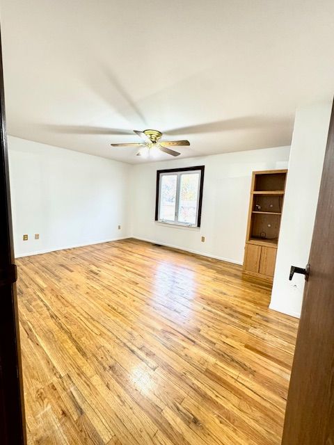 spare room with light hardwood / wood-style floors and ceiling fan