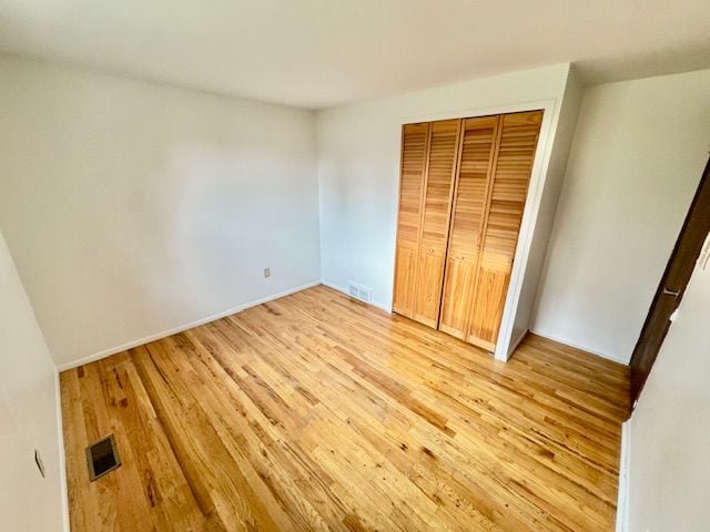 unfurnished bedroom featuring light wood-type flooring and a closet