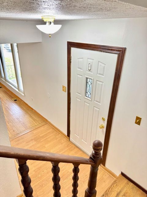 entryway featuring a textured ceiling and light wood-type flooring