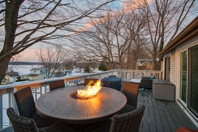 deck at dusk featuring a fire pit