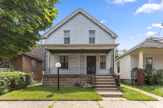 bungalow-style house with a front lawn and covered porch