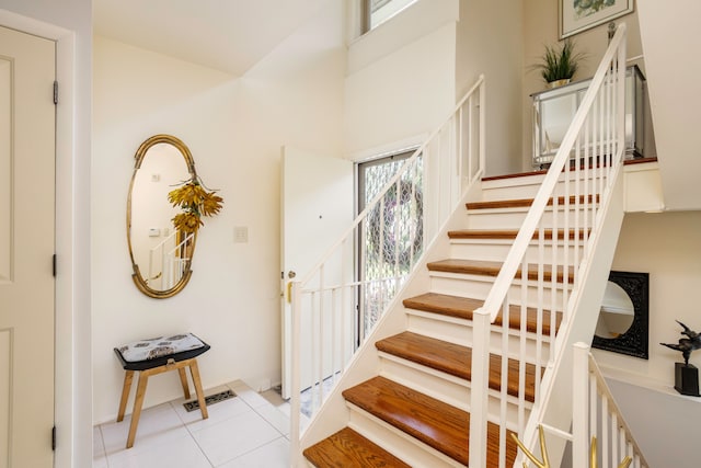 2100 Hyde Park Rd, Detroit, MI 48207 - foyer featuring stairs, light tile patterned flooring, a high ceiling, and baseboards