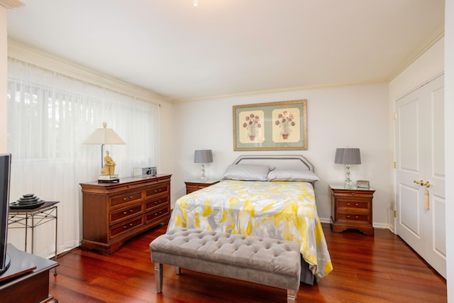 bedroom with crown molding and dark hardwood / wood-style floors