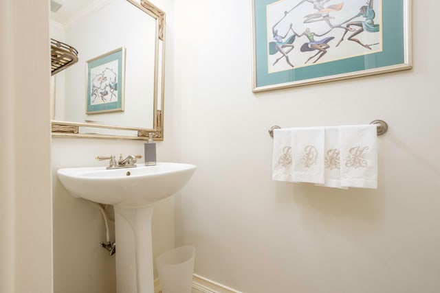 bathroom featuring ornamental molding and sink