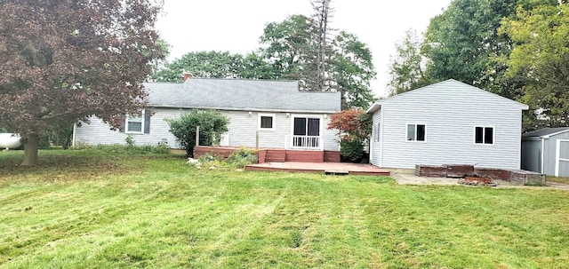 back of house with a storage shed, a yard, and a wooden deck