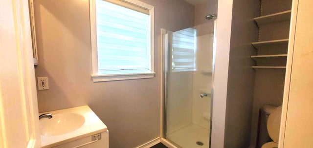 bathroom featuring toilet, vanity, and walk in shower