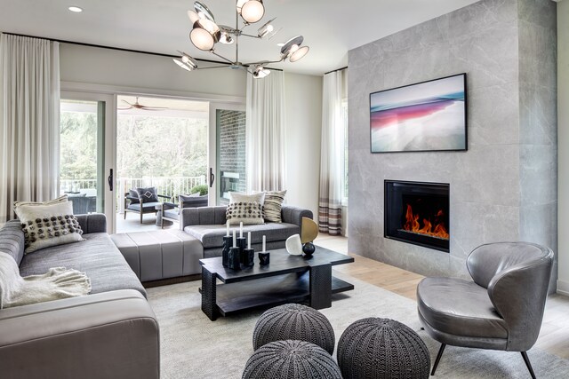 827 Larchlea Dr, Birmingham, MI 48009 - living area with light wood-style flooring, a tile fireplace, a chandelier, recessed lighting, and a ceiling fan