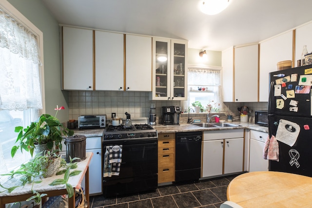 kitchen featuring black appliances, a healthy amount of sunlight, white cabinetry, and tasteful backsplash