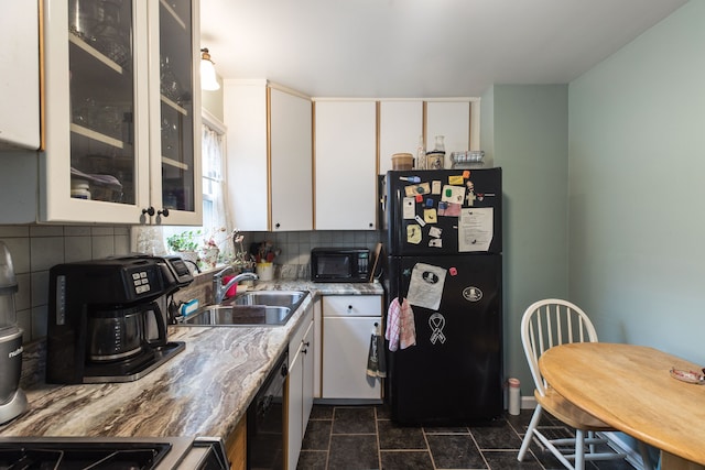 kitchen with white cabinets, backsplash, light stone counters, and black appliances