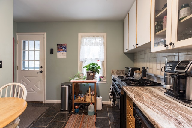 kitchen featuring white cabinets, black gas range, backsplash, and dark tile patterned floors