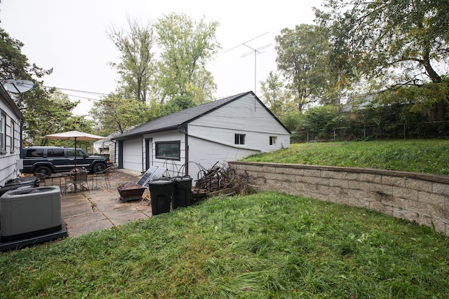 view of property exterior featuring a lawn, central AC, a patio, and a garage