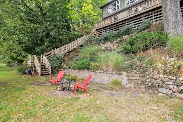 view of yard with a deck and an outdoor fire pit