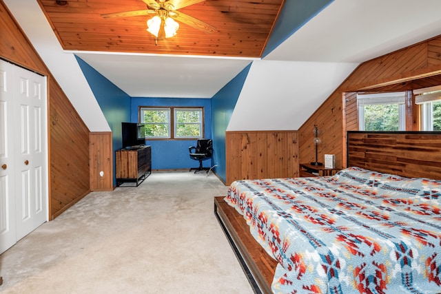 bedroom featuring vaulted ceiling, multiple windows, wooden walls, and ceiling fan