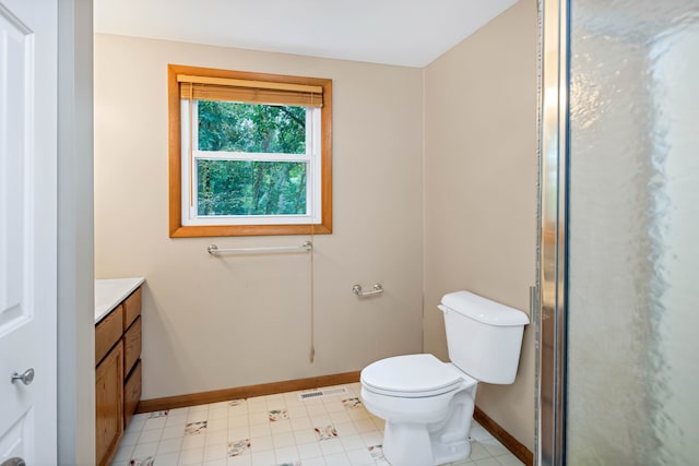 bathroom featuring tile patterned floors, vanity, toilet, and walk in shower