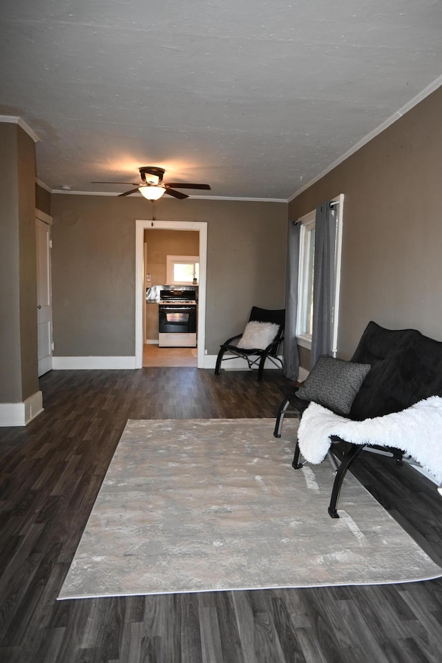 sitting room with ceiling fan, dark hardwood / wood-style flooring, and crown molding