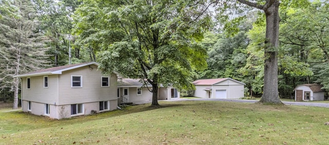 view of front of house featuring a garage, a shed, and a front yard