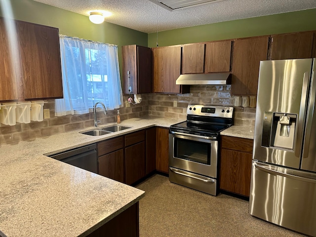 kitchen with decorative backsplash, a textured ceiling, stainless steel appliances, and sink