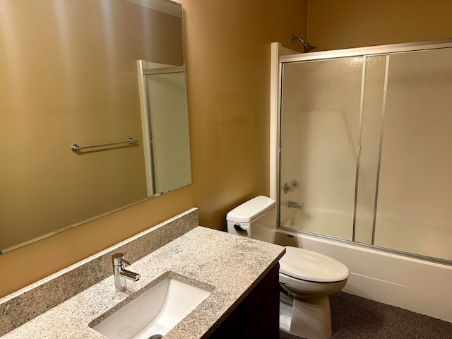 full bathroom featuring combined bath / shower with glass door, vanity, and toilet