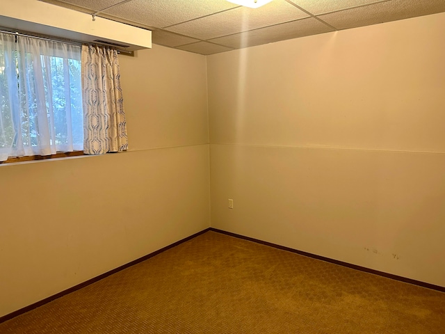 carpeted spare room with a drop ceiling