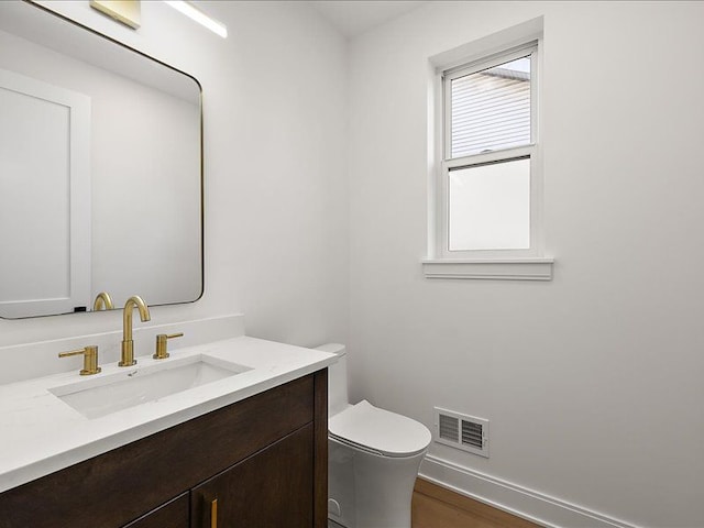 bathroom with hardwood / wood-style floors, vanity, and toilet