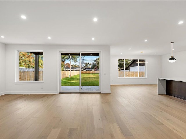 unfurnished living room featuring light hardwood / wood-style flooring and a wealth of natural light