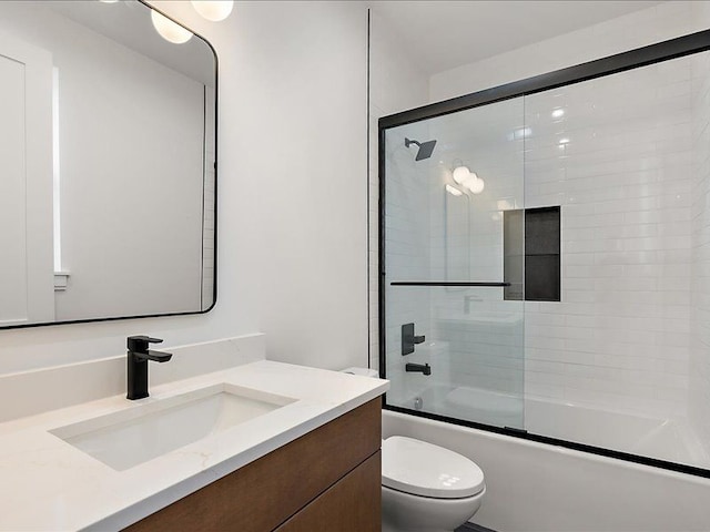 full bathroom featuring vanity, enclosed tub / shower combo, and toilet