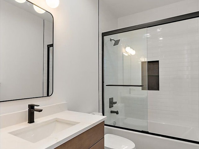 full bathroom with vanity, toilet, and shower / bath combination with glass door